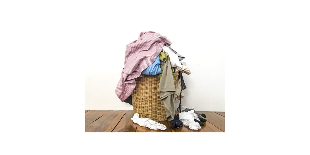 Messy overflowing laundry basket before Laundreams
